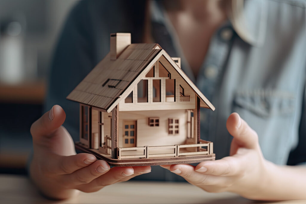 A miniature house being held in the hands